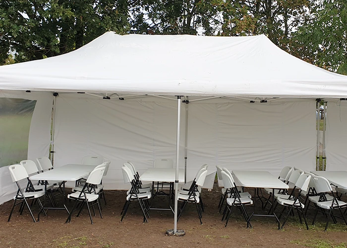 Mobilier pliant sous un barnum avec murs et fenêtre lors d'un événement
