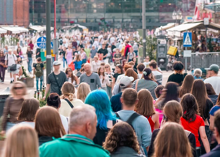 Foule de passants dans une rue commerçante, cible d'une opération de street marketing avec barnum