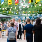 RSE, événement extérieur, guirlandes lumineuses et fanions colorés au-dessus d'une foule : exemple d'événementiel responsable