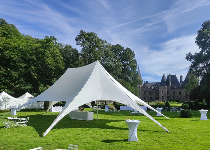 Tente étoile pour un mariage : réception en plein air avec mange debout et tables avec housses