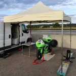 Barnum pliant blanc utilisé comme stand paddock pour une moto de course Kawasaki ZX-6R sur circuit